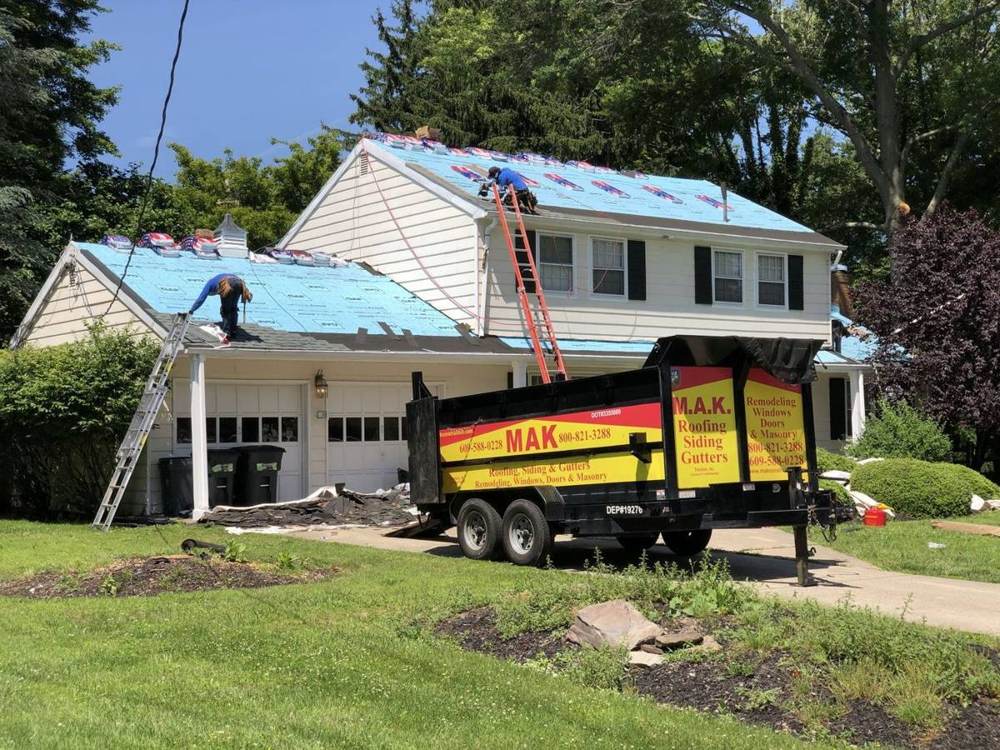 A crew installing a new shingle roof on a suburban home